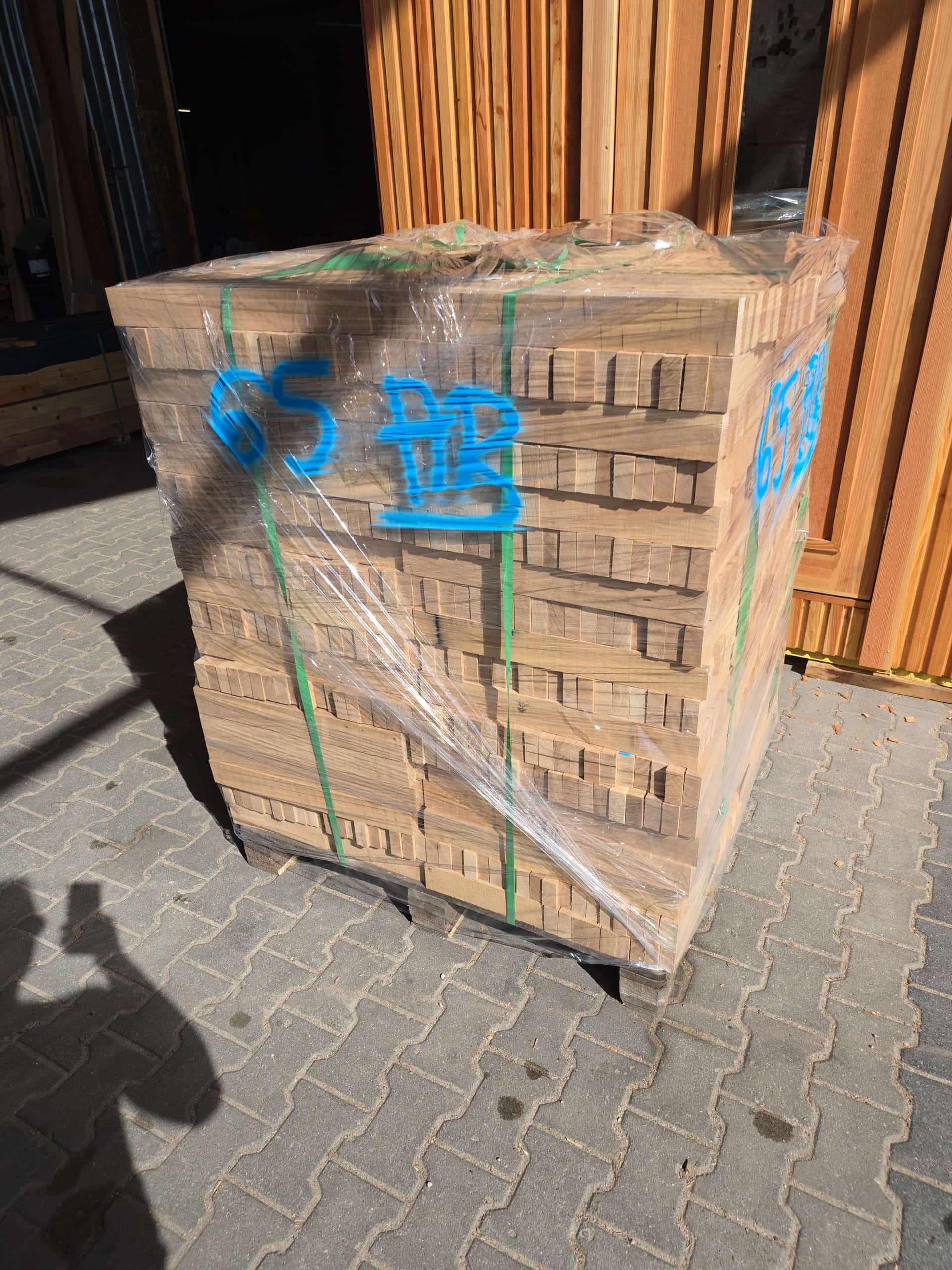 Paleta fryzów owinięta folią, oznaczenie w sprayu, kostka przed halą