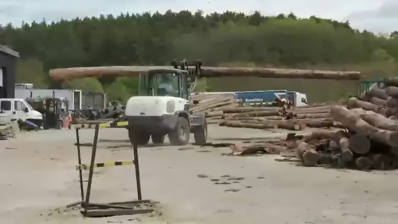 Ładowarka teleskopowa z kłodą na placu tartaku Drewno Pilarscy