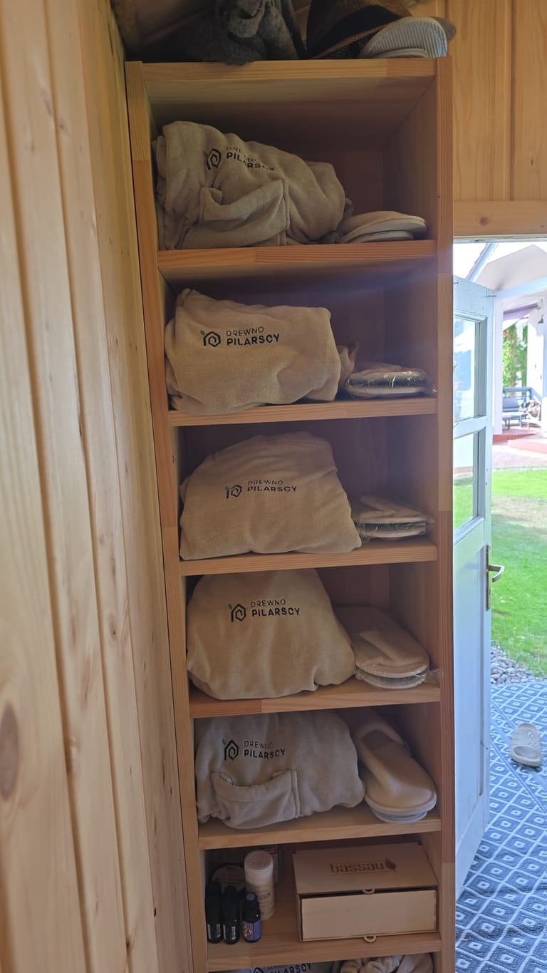 Półka z ręcznikami z logo marki we wnętrzu sauny